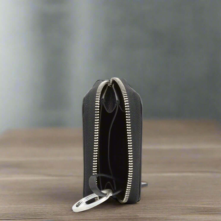 Black wallet with a silver zipper on a white background