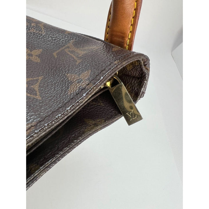 LOUIS VUITTON Looping GM Monogram Shoulder Bag close-up showing the golden zipper and leather details, luxury bags.