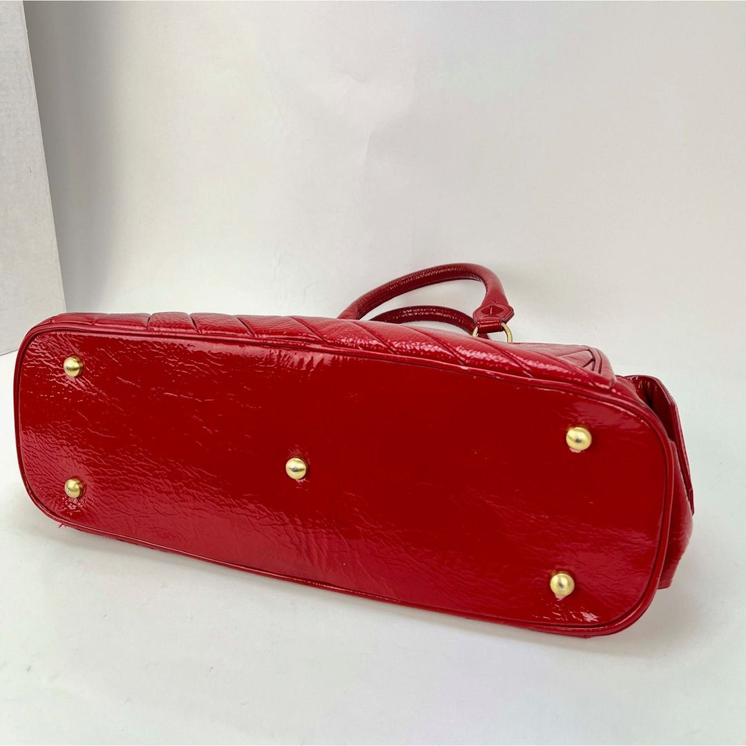 Isabella Fiore Red Patent Leather Hand bag bottom view showcasing luxury bags with minor signs of wear.