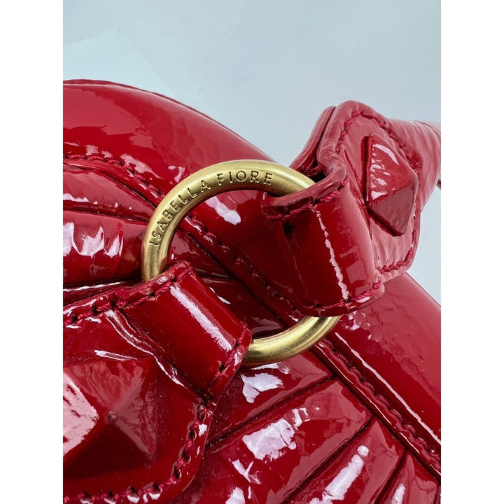 Isabella Fiore Red Patent Leather Hand bag close-up showing polished hardware and handle details, a luxury bag.