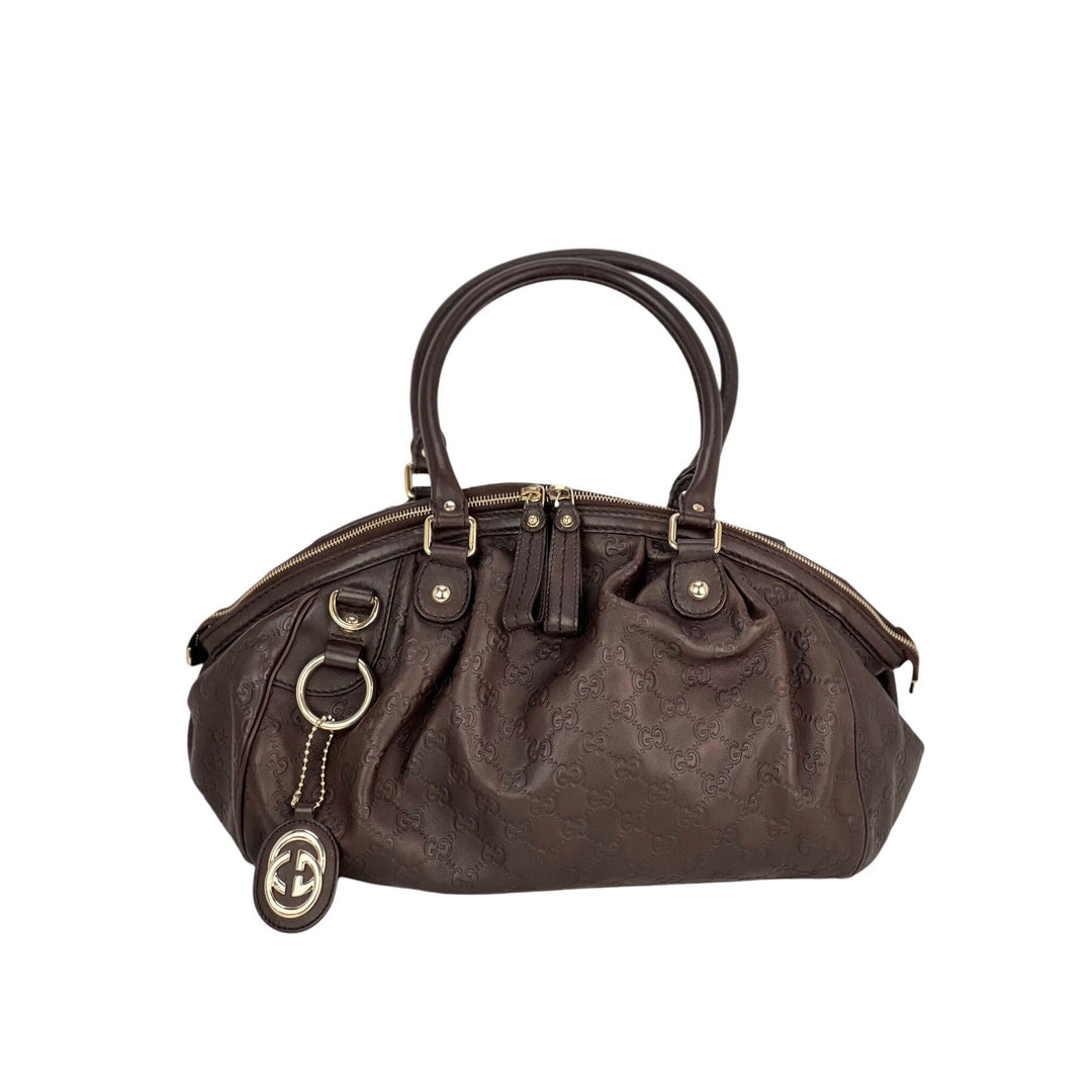 Brown handbag with gold accents on a white background