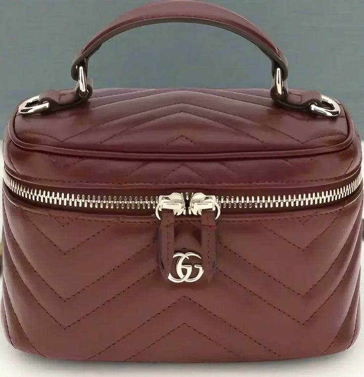 Quilted brown handbag with a silver logo on a white background