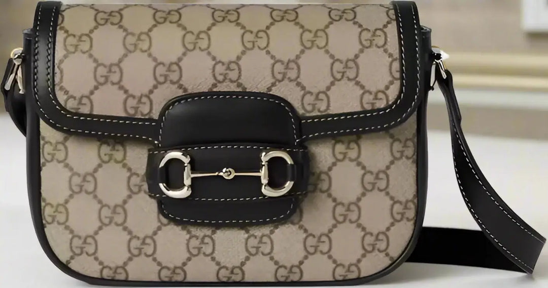 Designer handbag with monogram pattern and black accents on a white background