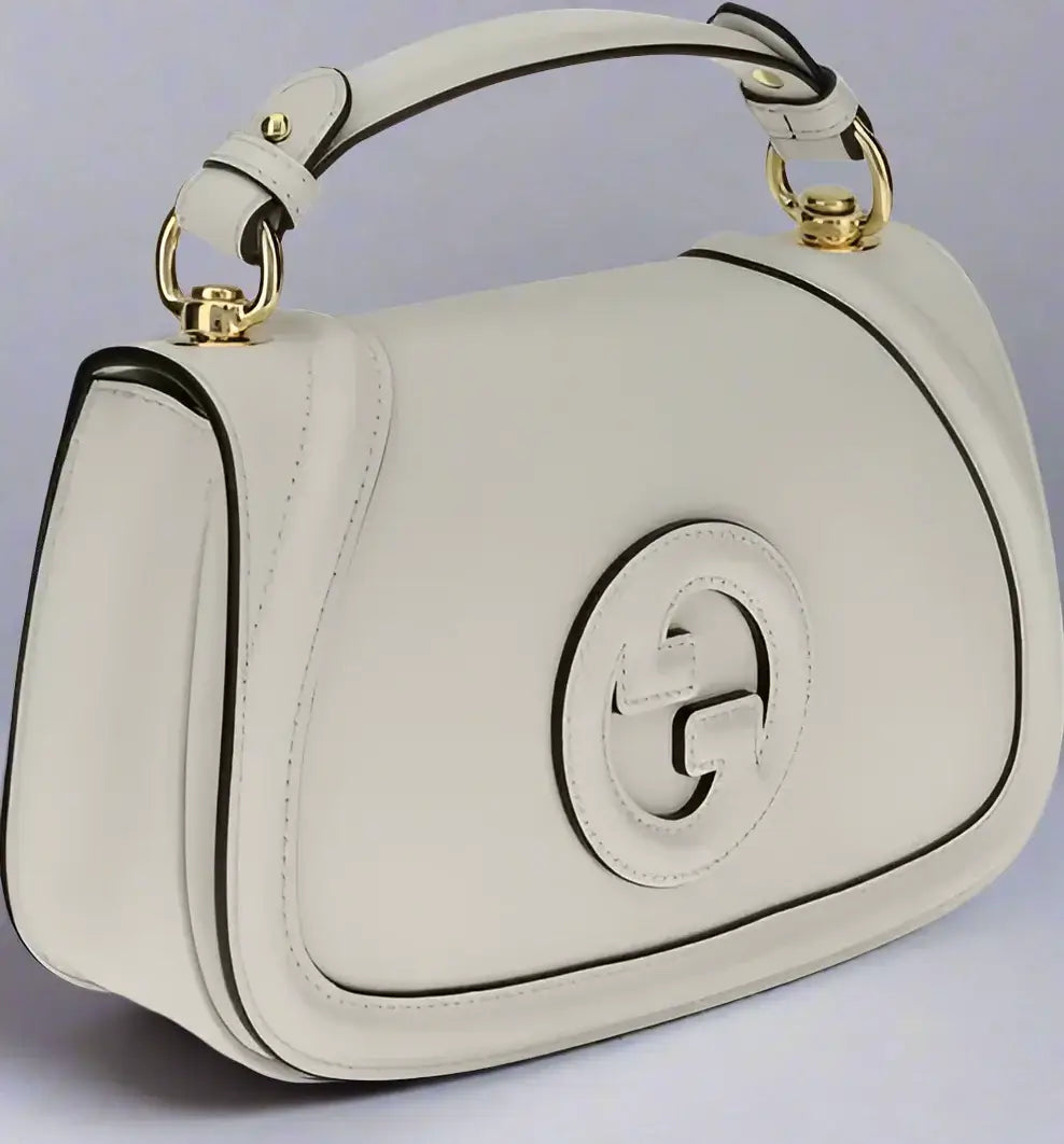 White handbag with gold accents on a white background