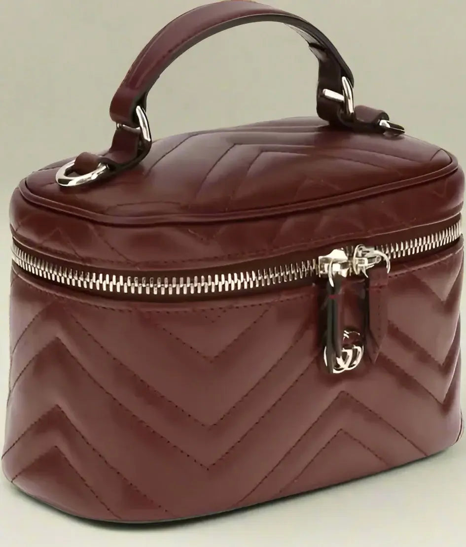 Brown quilted cosmetic bag with a gold zipper on a white background
