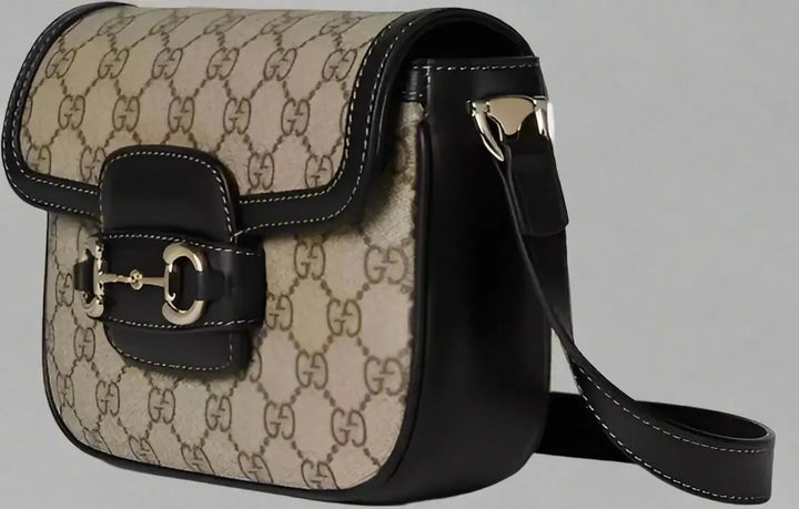 Beige handbag with black accents on a white background