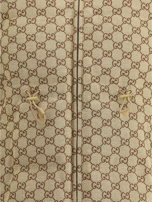 Close-up of a beige fabric with a repeated pattern, likely a brand logo.