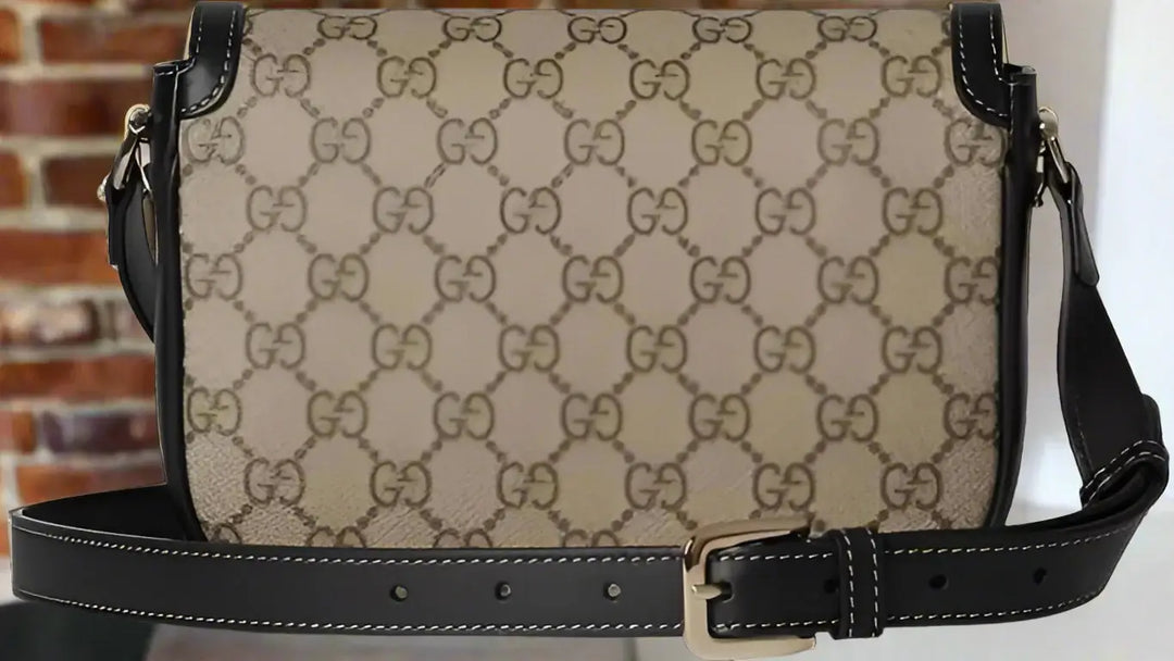 Beige handbag with black leather accents and a prominent brand logo on a white background