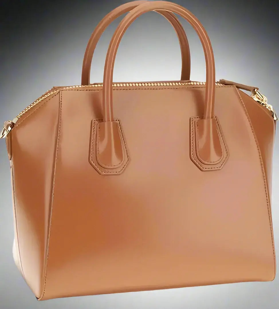 Tan handbag with gold accents on a white background