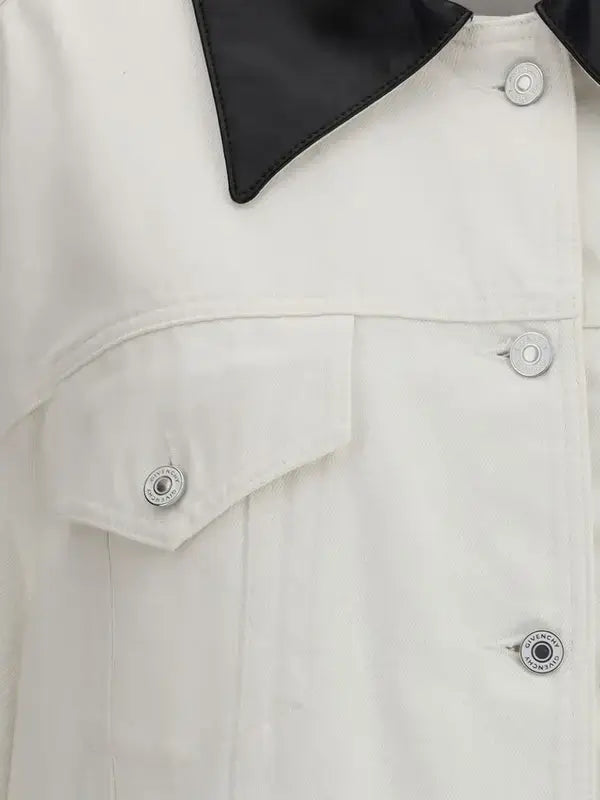 Close-up of a white coat with black collar and buttons.
