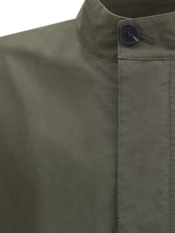 Close-up of a green jacket with a button on a white background