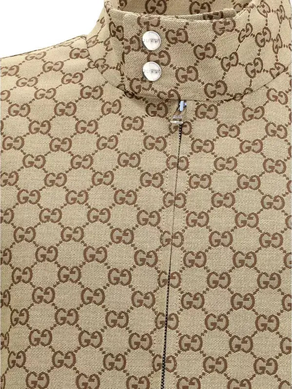 Close-up of a beige fabric with Gucci logo pattern and buttons.