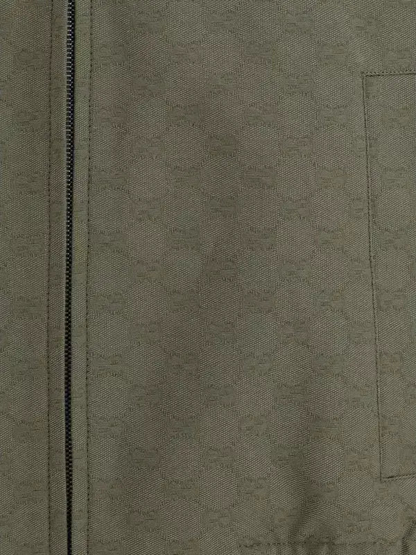 Close-up of a green fabric texture with a zipper on the left side.