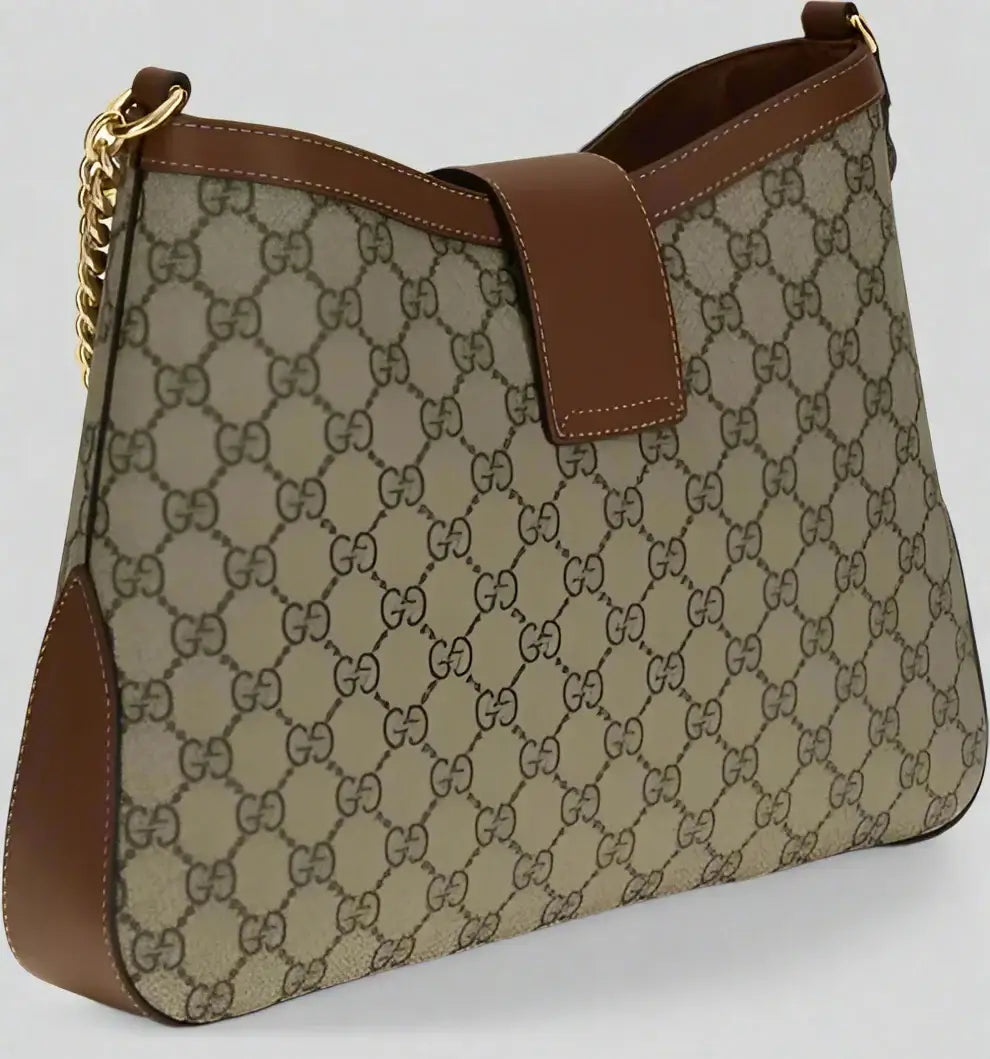 Designer handbag with patterned fabric and brown leather accents on a white background