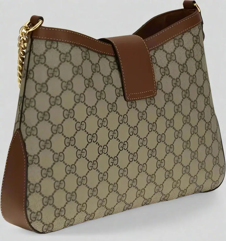 Designer handbag with patterned fabric and brown leather accents on a white background
