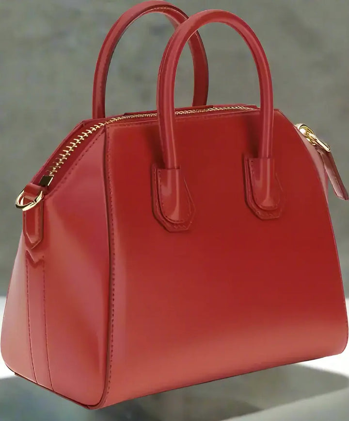 Red handbag with gold zipper on a white background