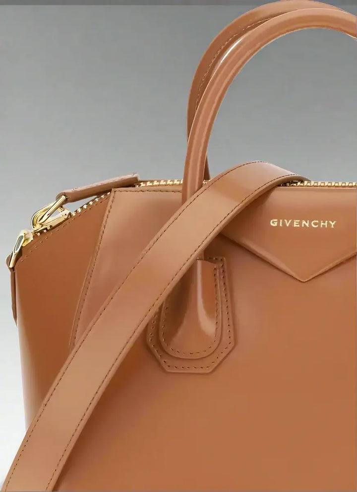 Brown Givenchy handbag with a gold zipper on a white background
