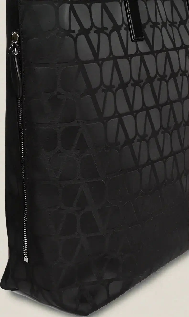 Black textured bag with a zipper detail on a white background