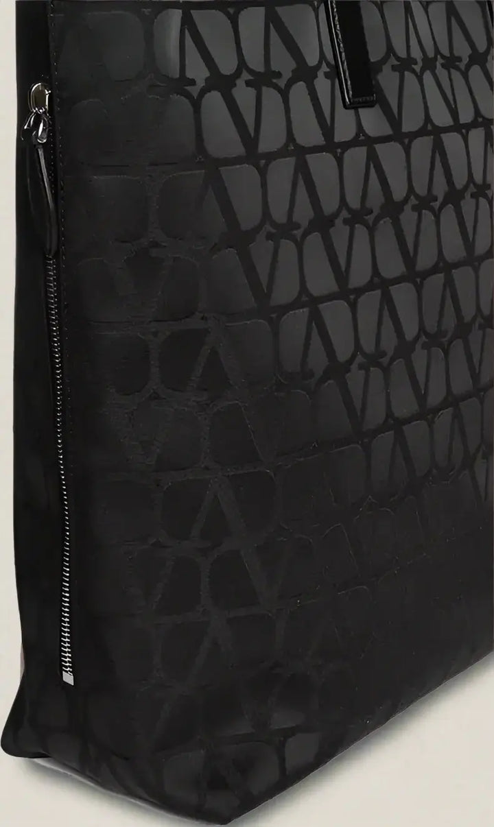 Black textured bag with a zipper detail on a white background