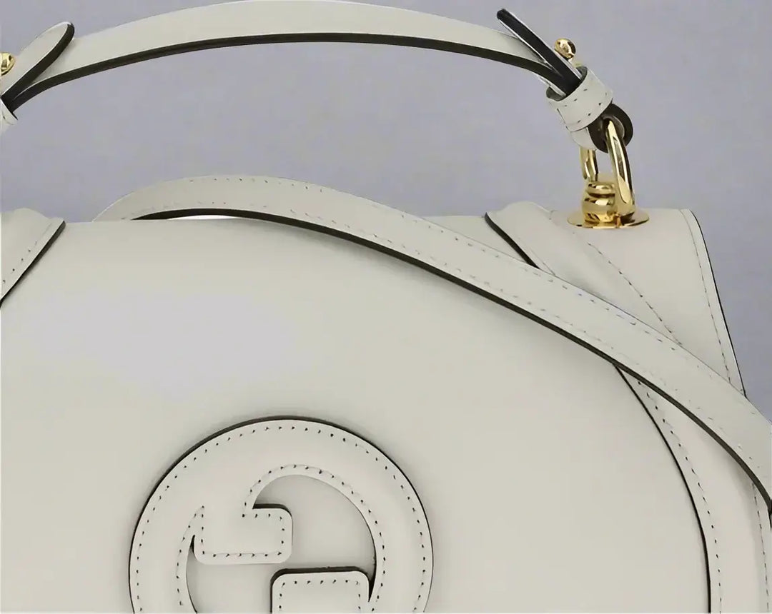 White handbag with gold accents on a white background