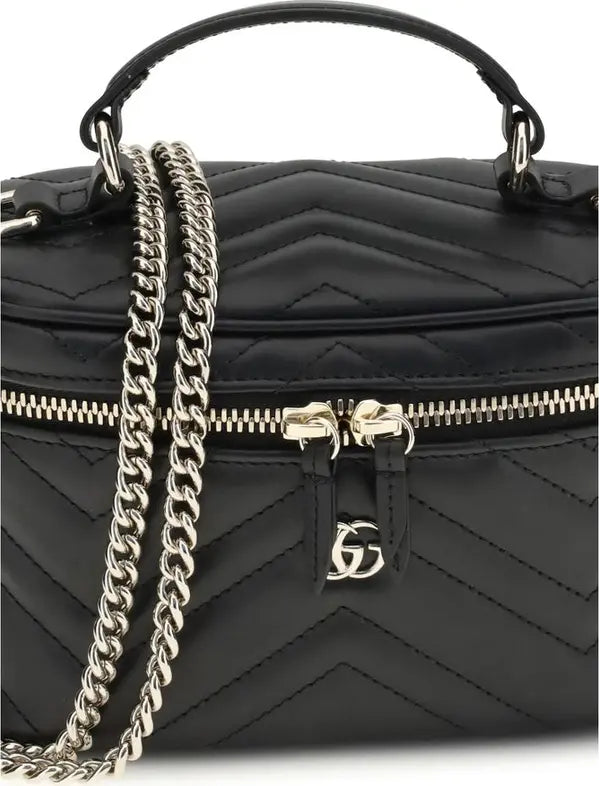 Black quilted handbag with gold chain and logo on a white background