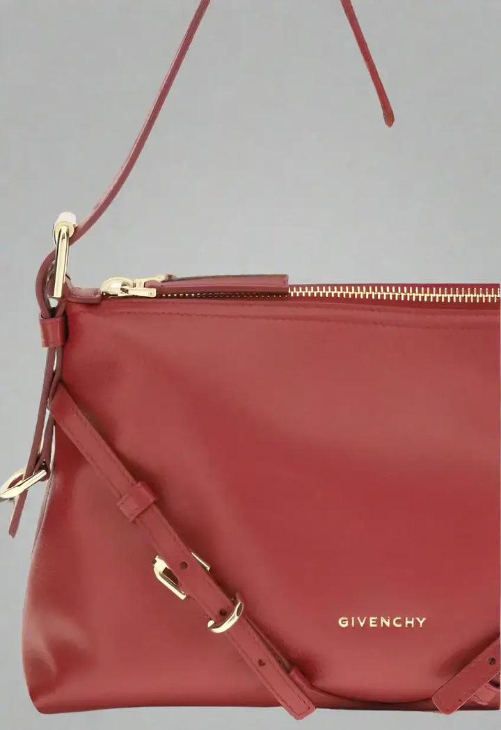 Red Givenchy handbag with gold accents on a white background