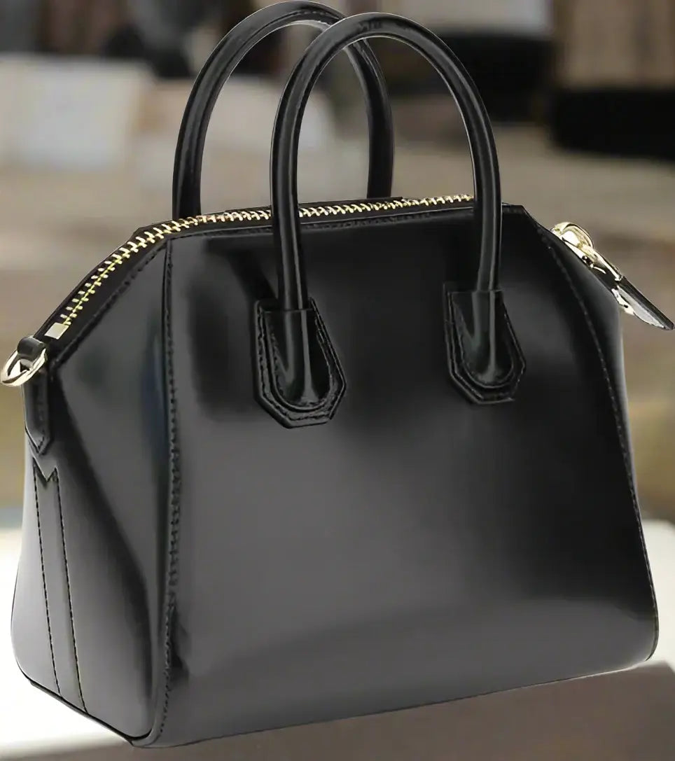 Black handbag with gold accents on a white background