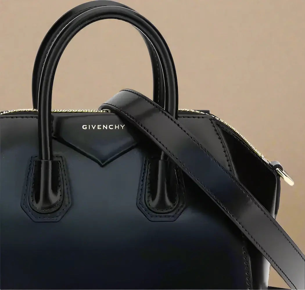 Black Givenchy handbag with a strap on a white background