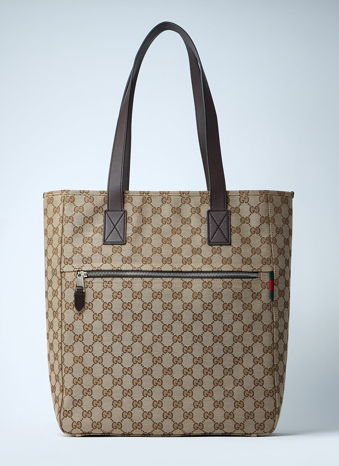 Beige patterned tote bag with brown handles on a light gray background