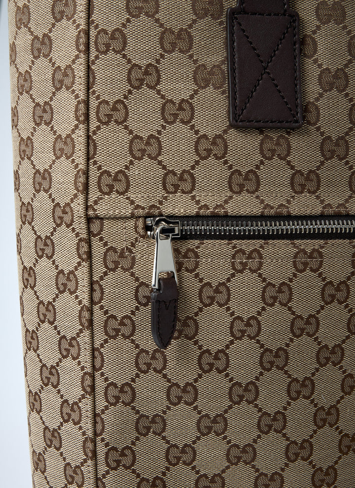 Close-up of a Gucci bag with monogram pattern and zipper detail.