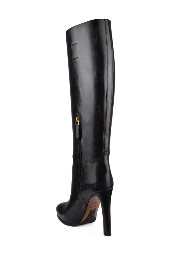 Black knee-high boot with a high heel on a white background
