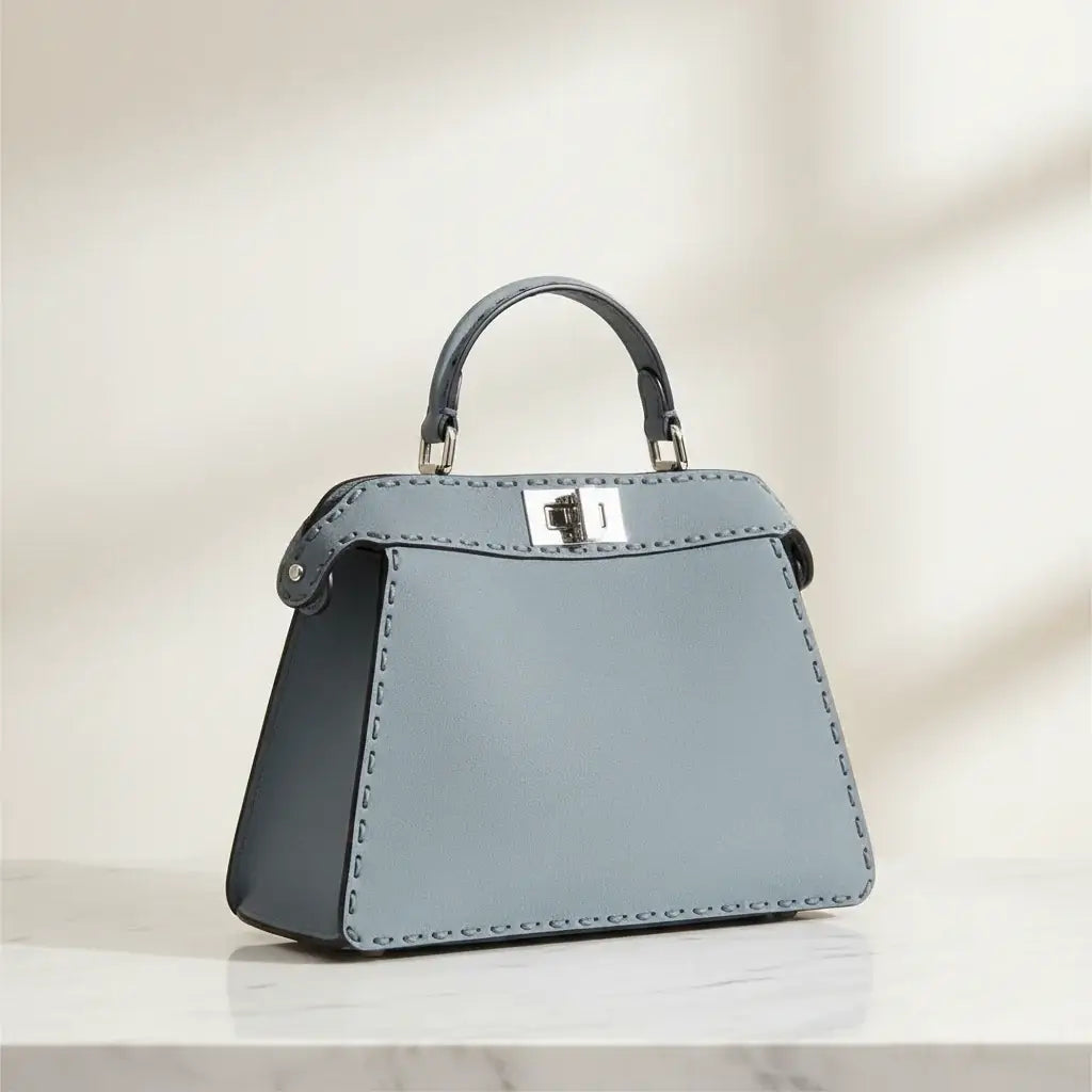 Gray handbag with a silver clasp on a white background