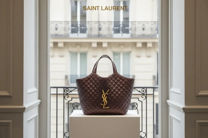 Brown quilted handbag with a gold logo on a white background