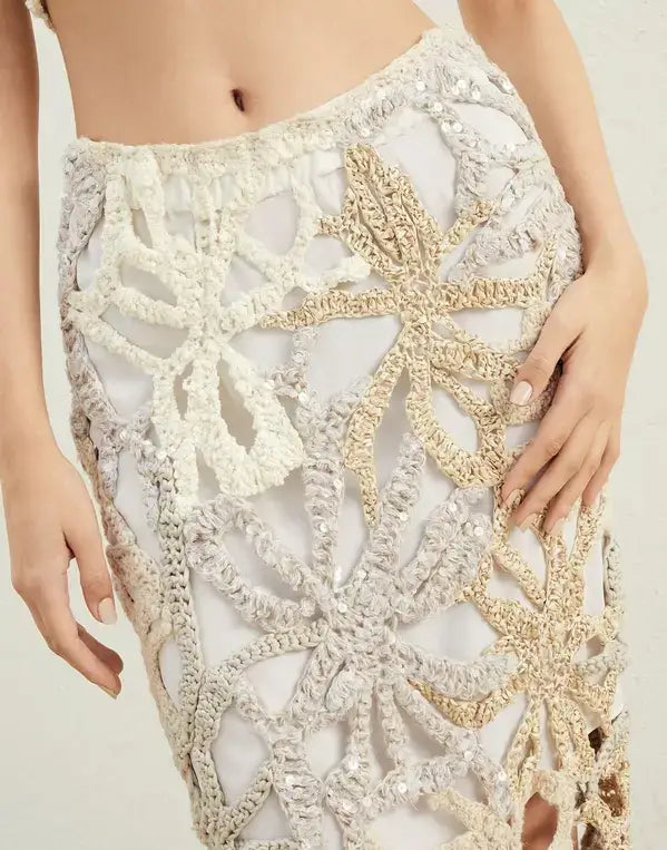 Close-up of a person wearing a crochet skirt with intricate patterns.