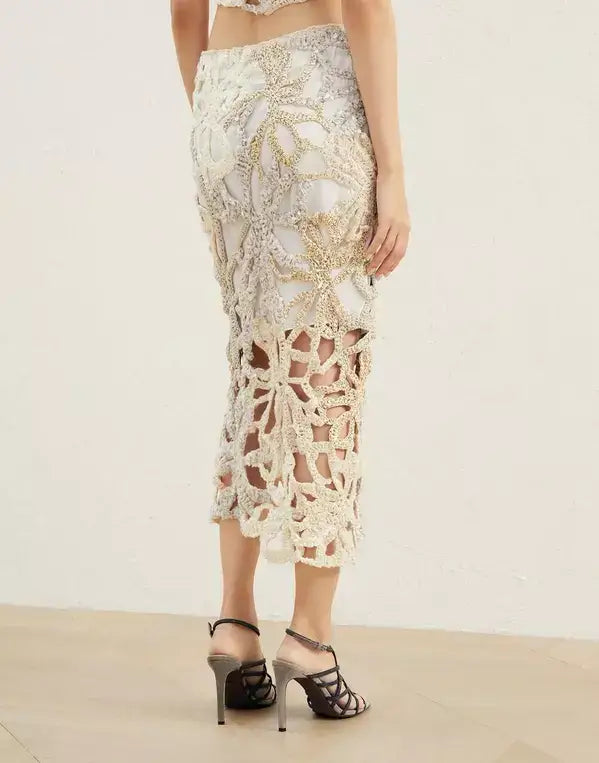 Person wearing a detailed lace skirt on a plain background
