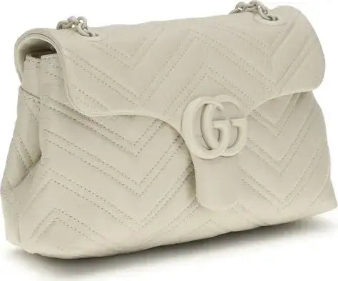Beige quilted handbag with a brand logo on a white background
