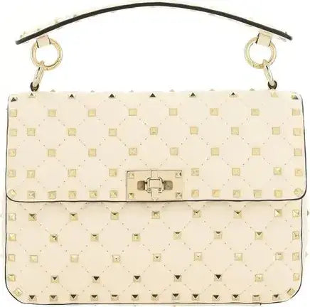 Beige handbag with gold studs and a gold clasp on a black background