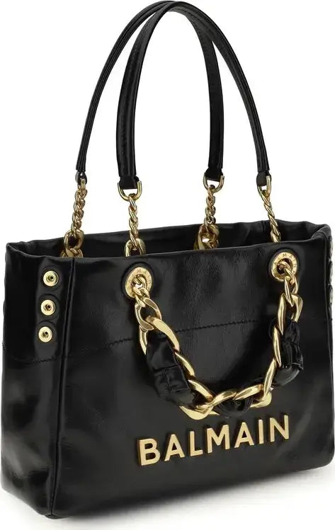 Black handbag with gold chain details and Balmain logo on a white background