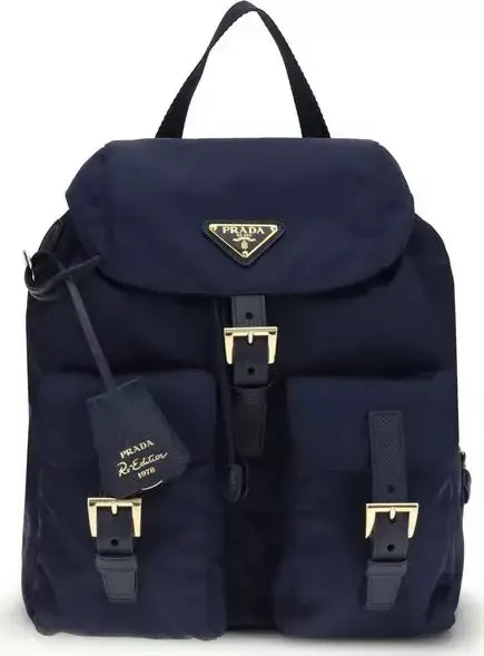 Navy blue Prada backpack with gold buckles on a white background