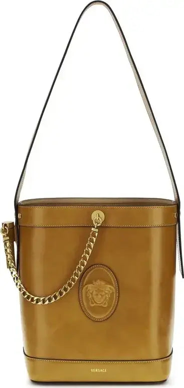 Brown leather bucket bag with gold chain and Versace logo on a white background