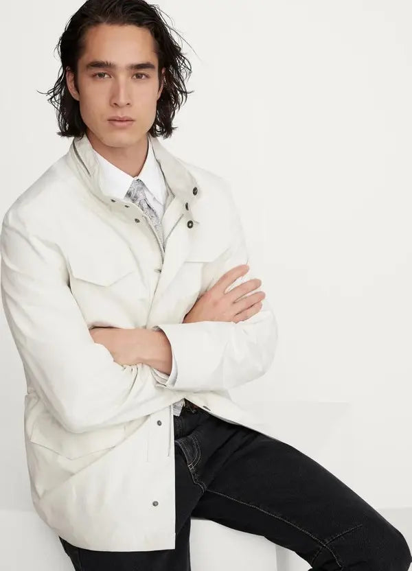 Man wearing a white jacket over a shirt with a white background