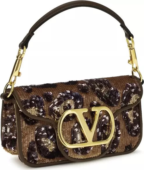 Designer handbag with decorative elements and a prominent logo on a white background