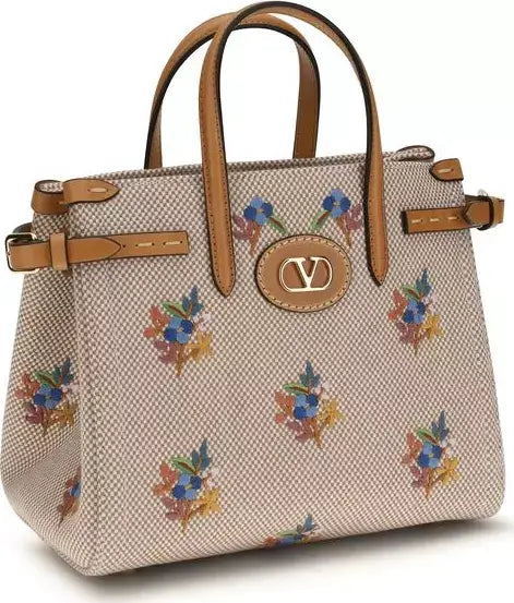 Handbag with floral pattern and brown handles on a white background