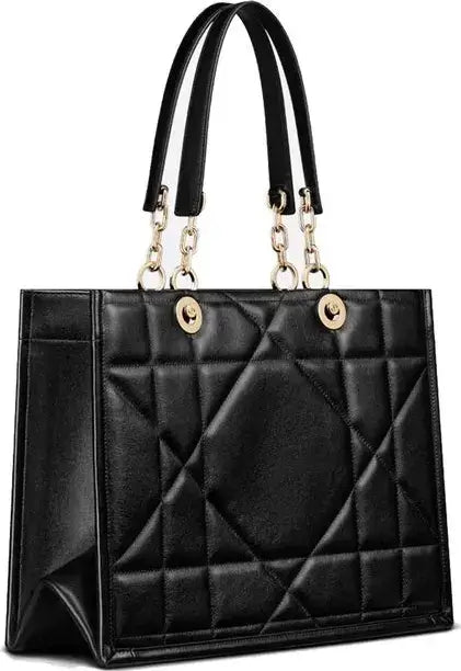 Black quilted handbag with gold accents on a white background