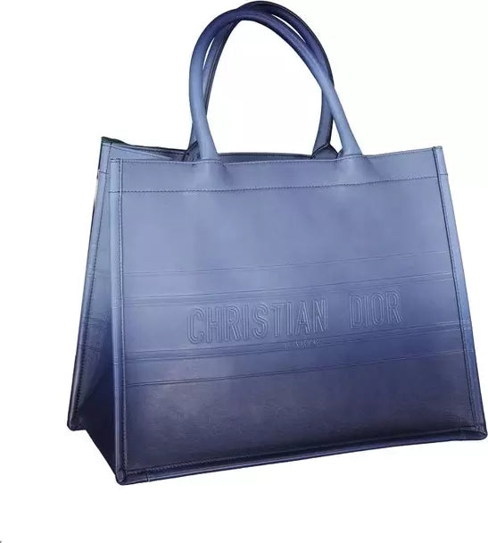 A dark blue Christian Dior tote bag with embossed branding on the front, set against a plain white background.