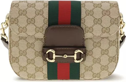 Designer handbag with GG pattern and iconic web strap on a white background