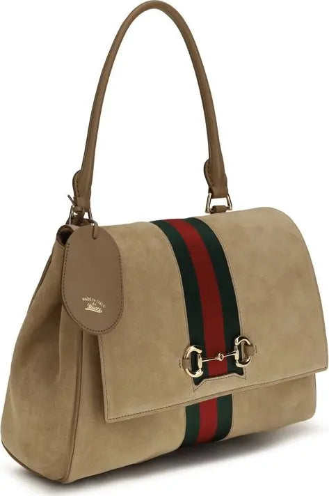 Beige handbag with a red and green striped strap on a white background