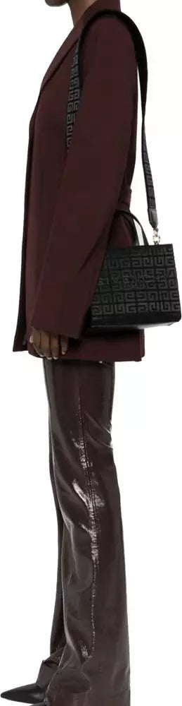 Person wearing a dark coat and holding a textured black handbag.