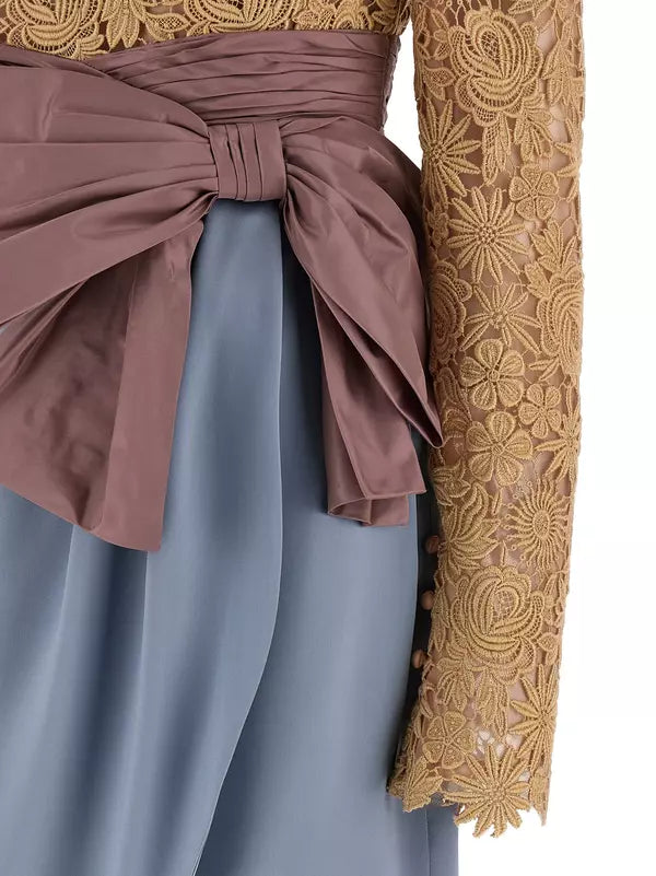 Close-up of a dress with gold lace sleeves and a brown belt.