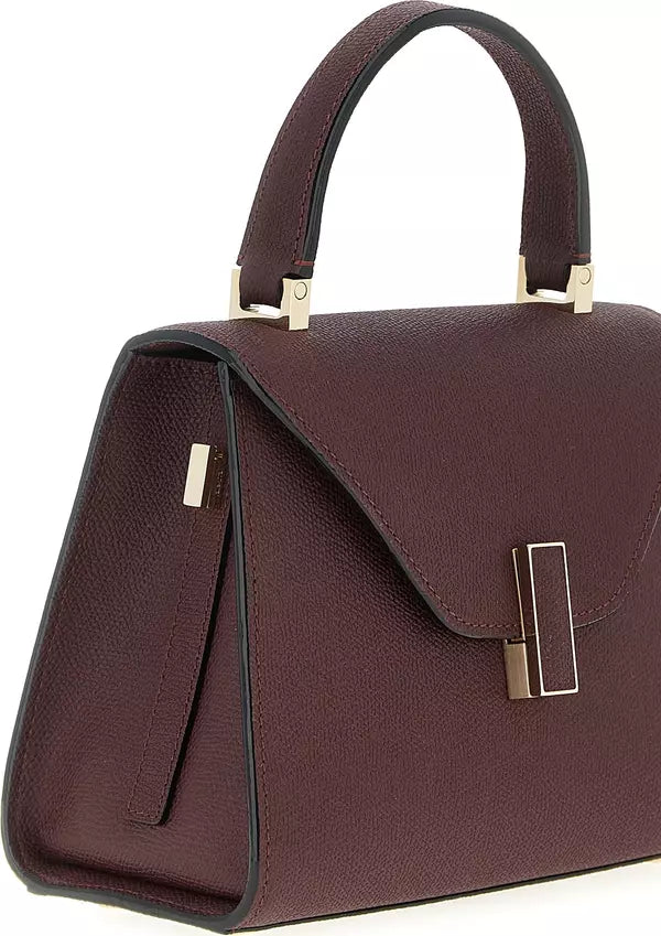 Burgundy handbag with gold accents on a white background